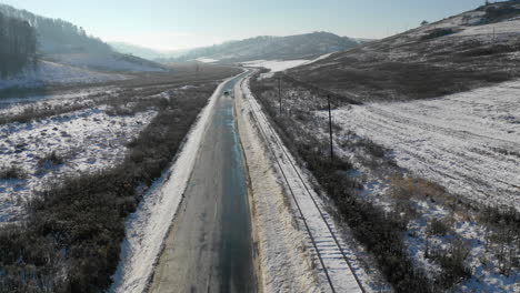 beautiful snow landscape with car driving on a road