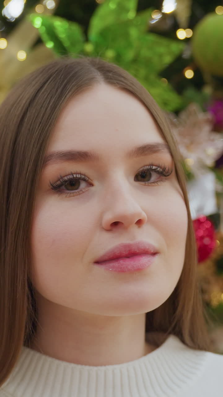 Elegant lady posing confidently in front of camera while standing in a decor store filled with festive decorations and Christmas-themed ornaments