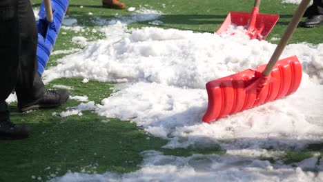 Men using red blurry snow shovel