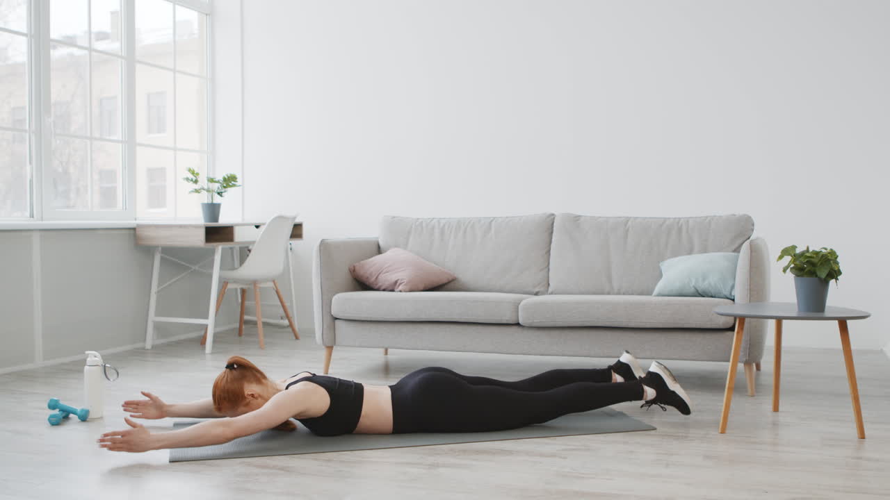 mujer haciendo ejercicios de espalda en casa