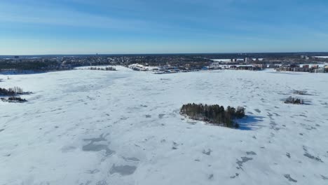 Drone-video-over-a-frozen-lake-during-daytime-with-small-islands-and-trees