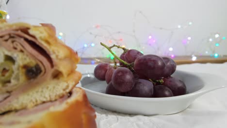 close-up of fresh grapes on a white plate with colorful holiday lights in the background