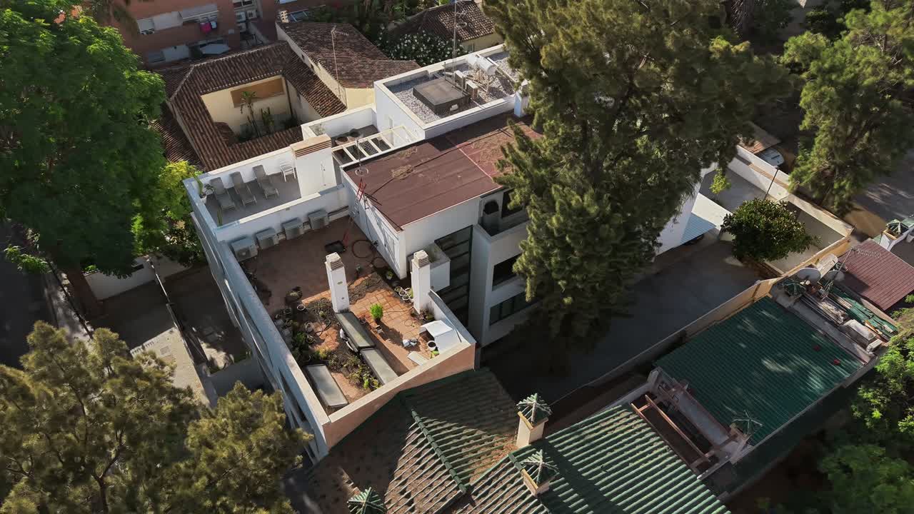 Aerial orbit above roof terrace of white apartment building , Spain