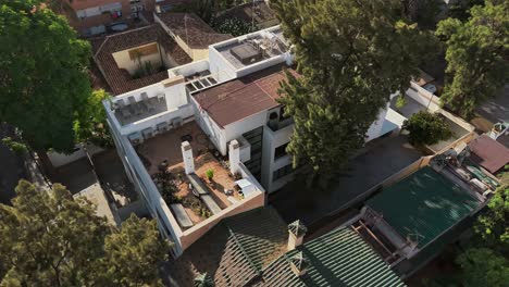 Aerial orbit above roof terrace of white apartment building , Spain