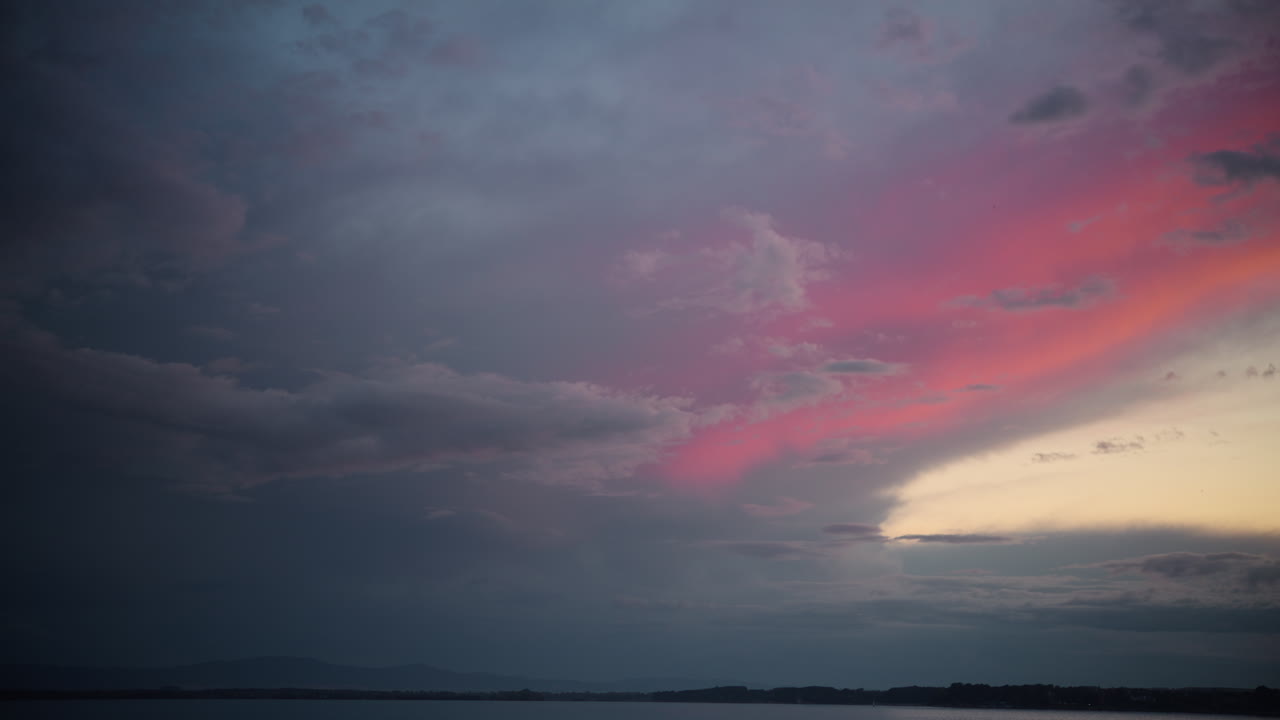 海にピンク色の雲がかかったドラマチックな夕焼け空