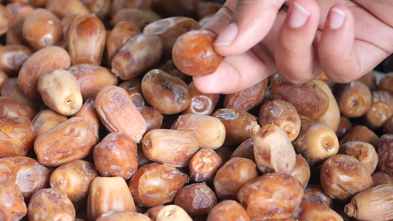 Hand picking dates from a pile