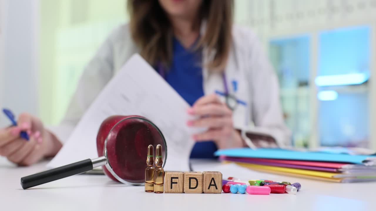 Bloques de madera deletrean la abreviatura FDA junto a un mazo y tabletas en cápsulas