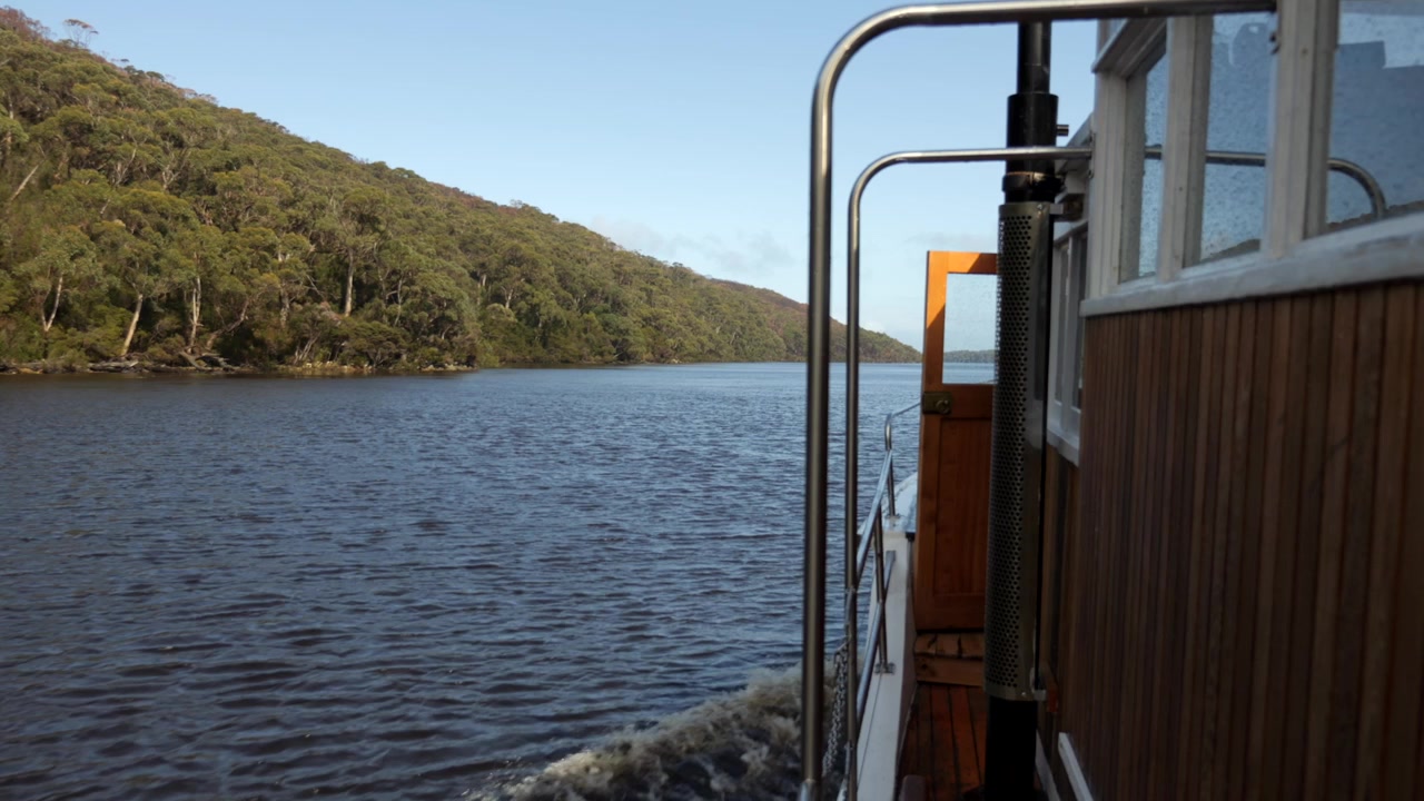 Seitenansicht eines alten hölzernen Dampfschiffs auf einer Kreuzfahrt in Tasmanien. Sonniger Tag im Regenwald. Zeitlupenaufnahme. Pieman River Kreuzfahrt. Corinna, Tasmanien, Australien