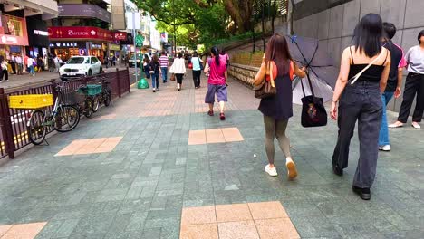 pedestrians stroll along a busy urban sidewalk