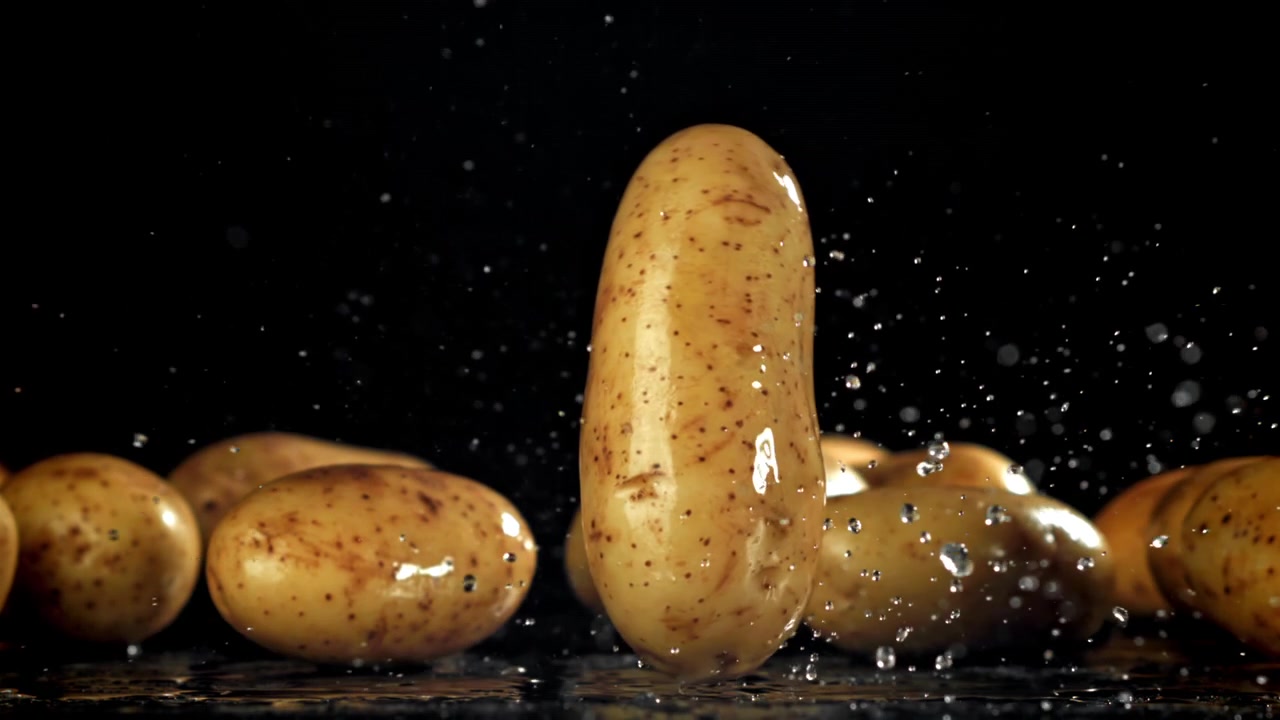 Patata fresca che cade e schizza acqua al rallentatore
