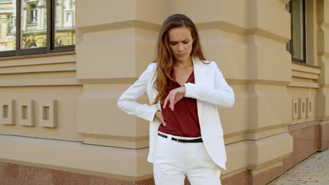 serious business woman waiting for meeting outdoors. woman checking time