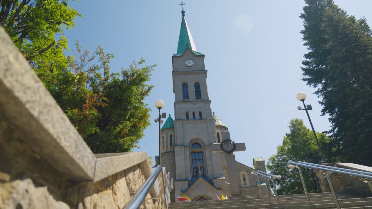 Ripresa dal basso che sale le scale in pietra verso la Chiesa della Sacra Famiglia a Zakopane, Polonia