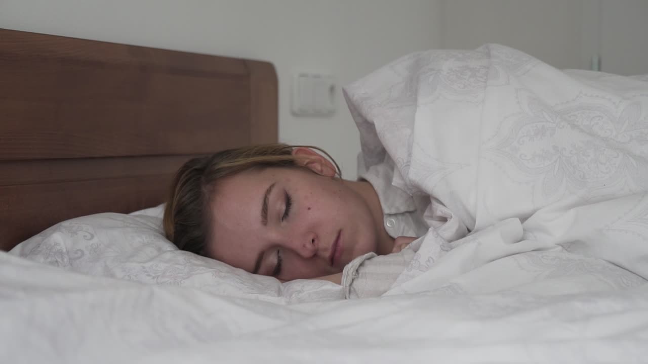 Sleeping caucasian brunette girl in bed side slider