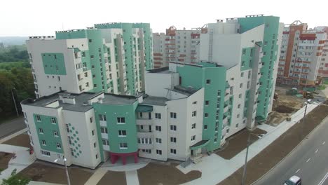 modern multy-storey building in newly built district near the beautiful green landscape. new design for high structure. camera motion bottom up