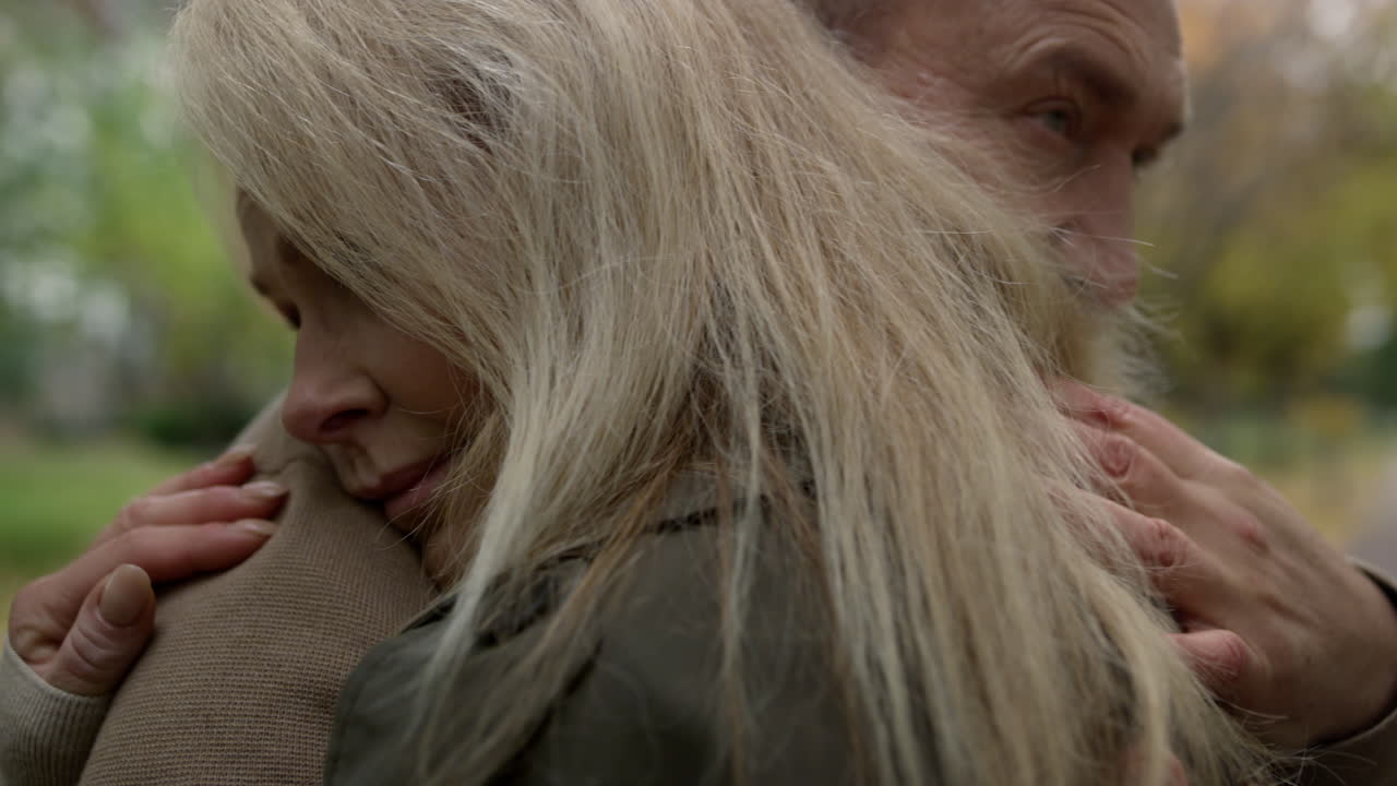 Close up around shot of adult lovers hugging each other outdoors. Togetherness.