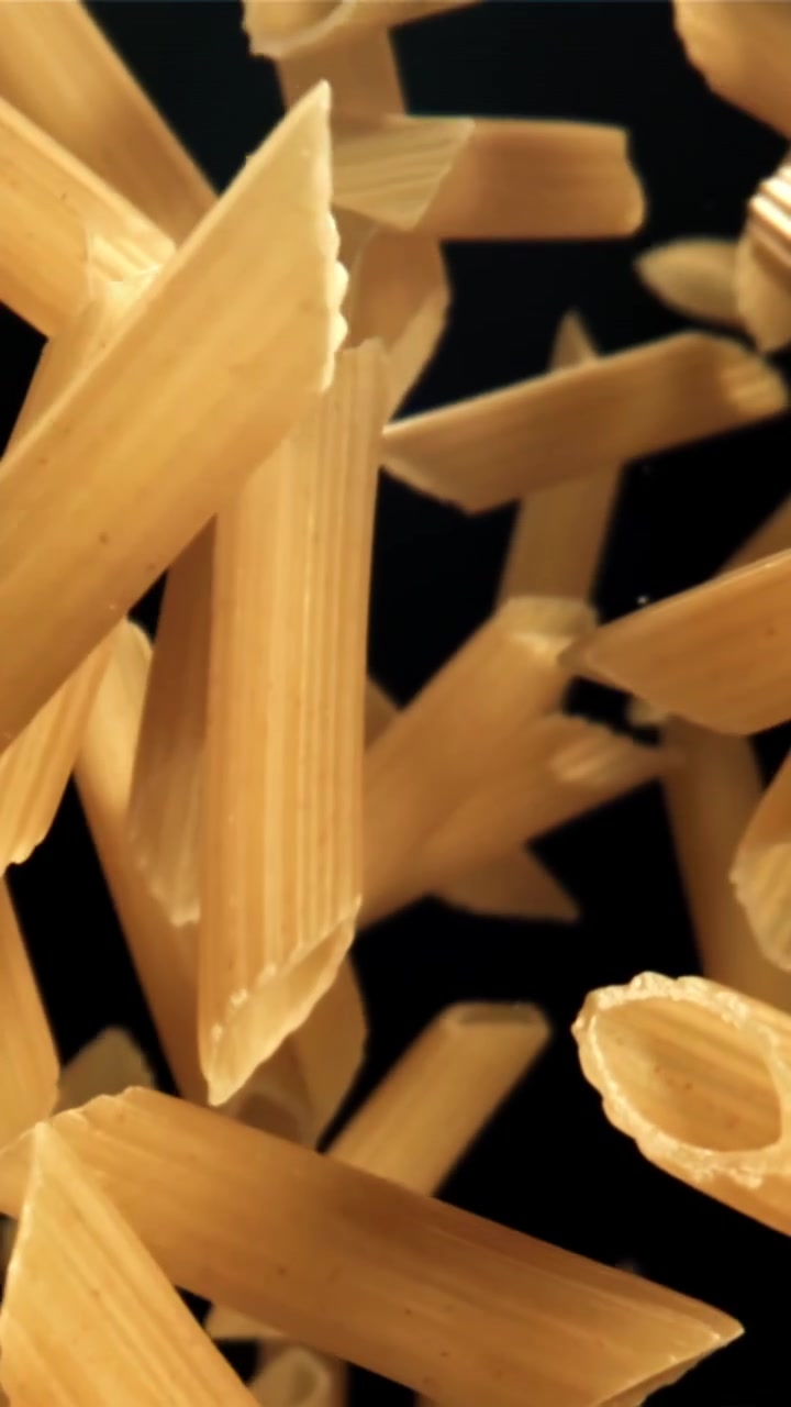 Penne secche che fluttuano verso l'alto su sfondo nero