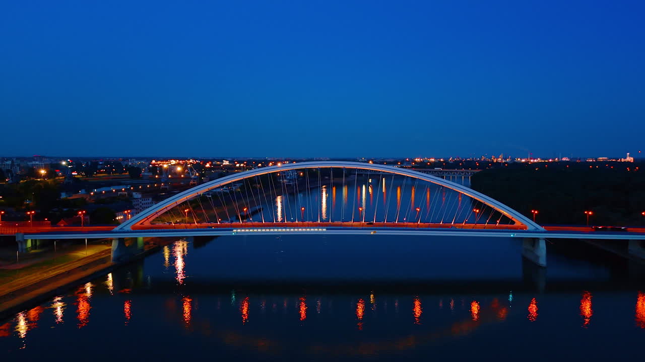 Transport moves by the beautiful arched bridge at night. Footage above the Danube river in Bratislava, Slovakia