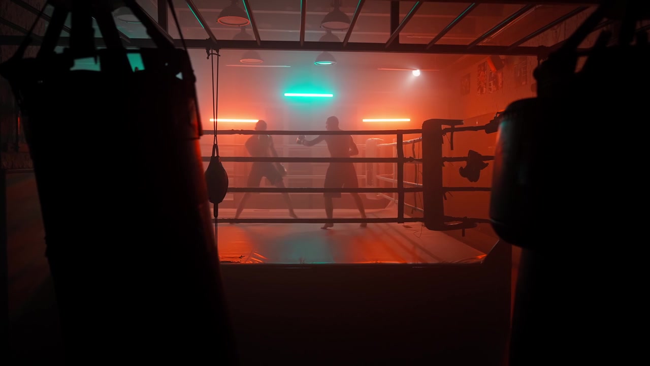 Silhouetten von Boxern beim Sparring in einem rauchigen, neonbeleuchteten Boxring