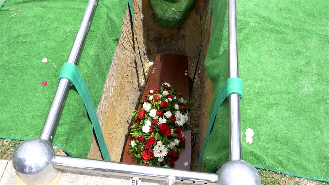 captura de pantalla de un ataúd funerario en un coche fúnebre o capilla o entierro en el cementerio