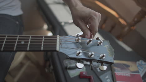 a person is adjusting his guitar