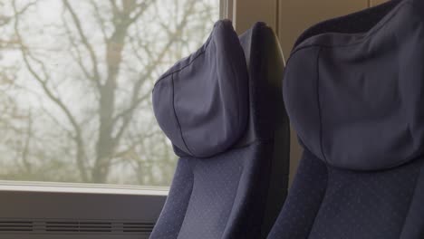 seats in a german ice high-speed train with soft fabric covers and window view