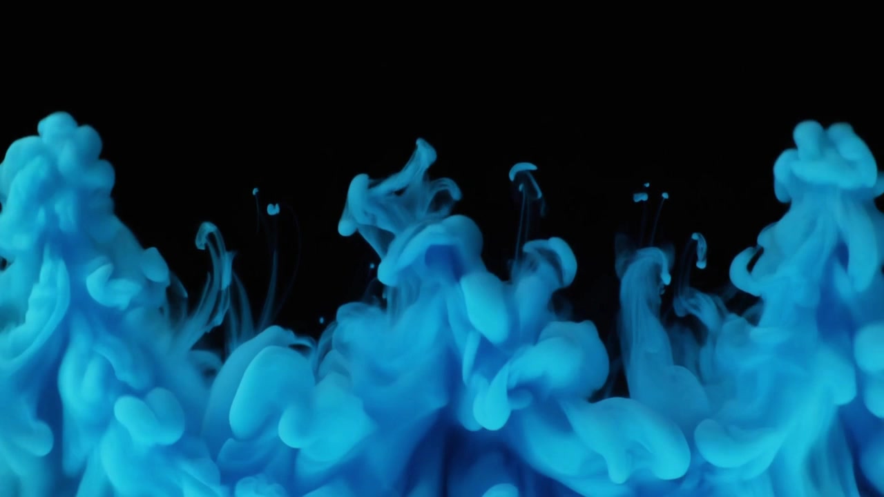 Inchiostro blu che si diffonde nell'acqua su sfondo nero