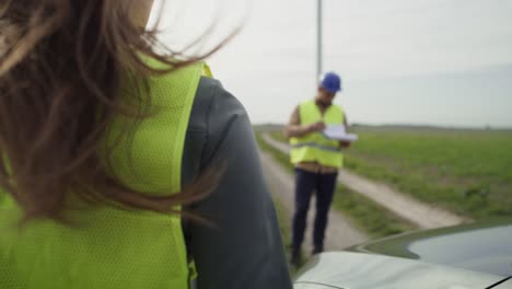 una mujer caucásica vino al campo con un molino de viento y habló con un ingeniero latino.