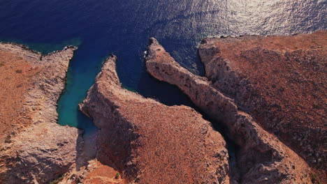 aerial view of rugged coastline and clear blue water in a serene bay