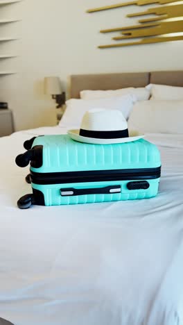 ready for the sun, with a straw hat and stylish luggage