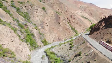 road and a ice water crossing thought the dry mountains in ladakh, india