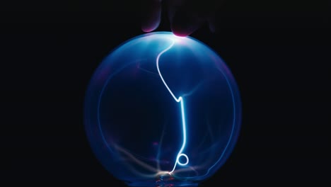 touching plasma ball on black background
