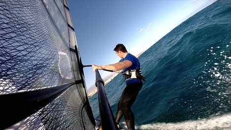 a rear view of an active windsurfer planing across the ocean