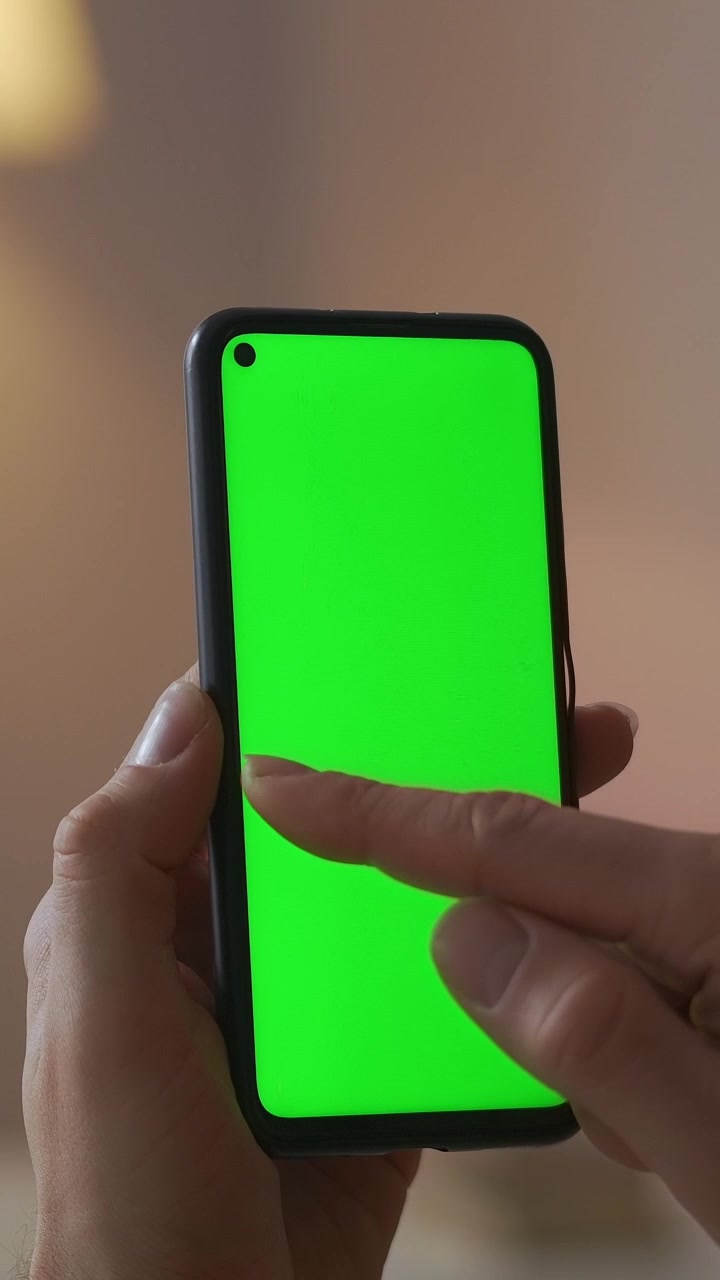 Primo piano di mano che scorre su smartphone con schermo verde
