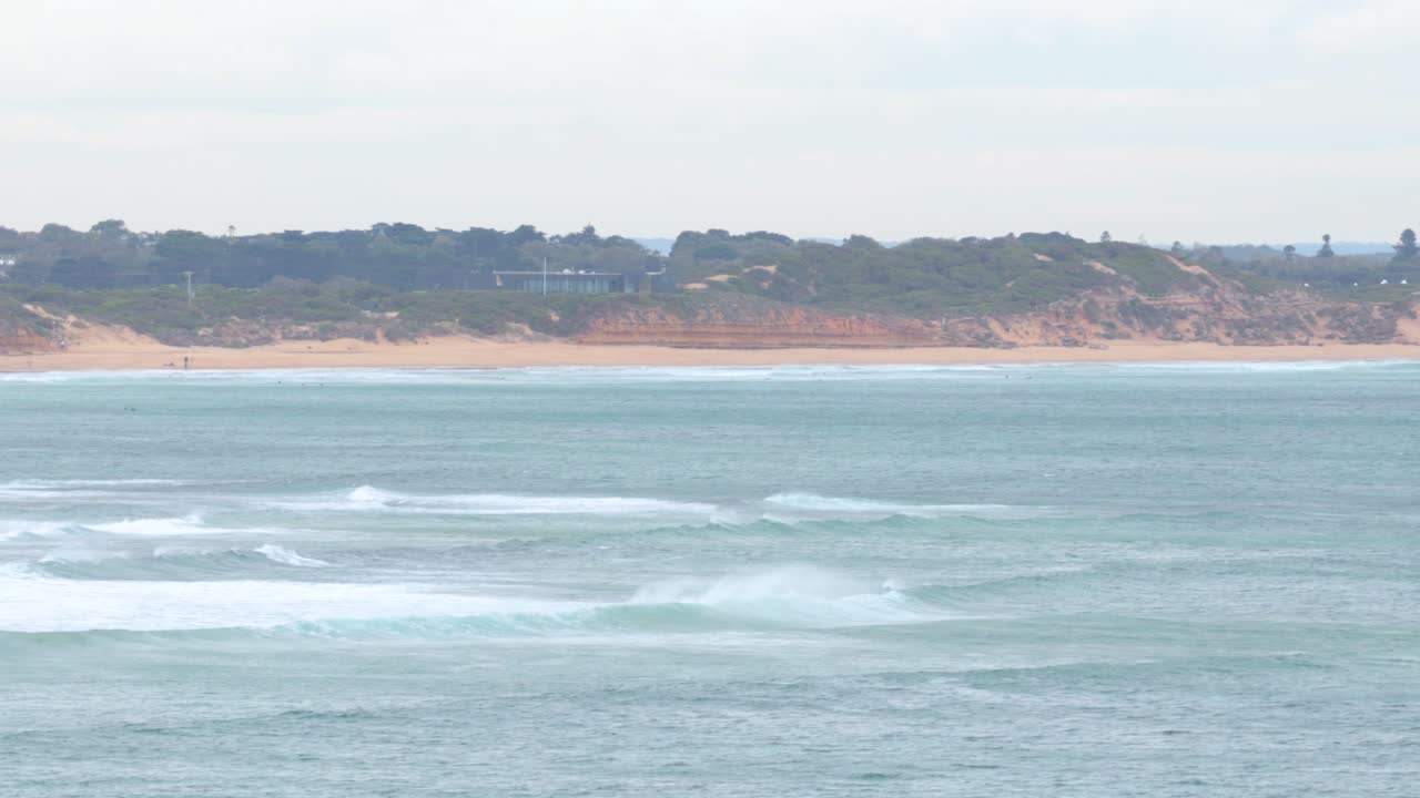 평온한 해안 풍경은 천천히 절벽에 부히는 파도를 보여줍니다. 위대한 바다 도로를 따라, 자연의 낮빛에 포착되었습니다.