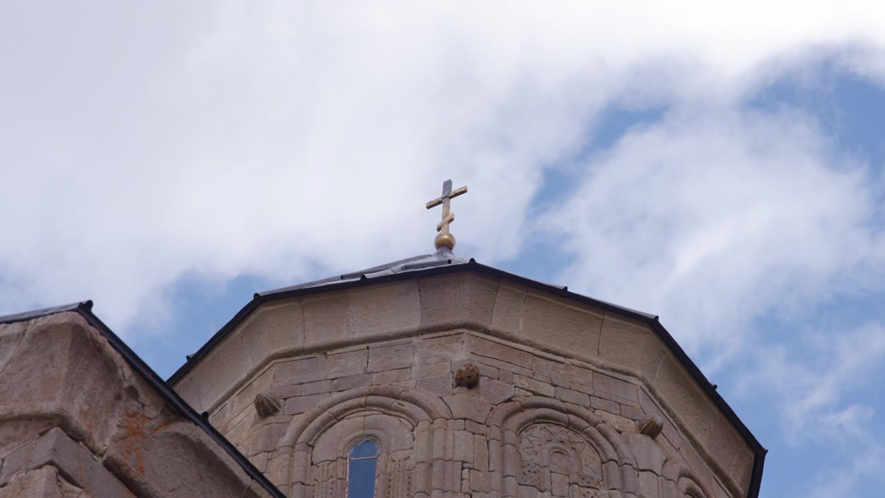 Mraky plující nad starobylým kostelem.
