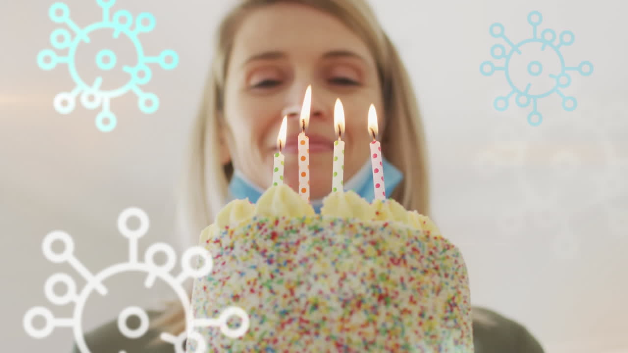 animación de las células del virus covid 19 sobre una mujer caucásica feliz que usa una máscara facial celebrando su cumpleaños