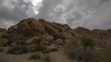 Timelapse-De-Cielo-Nublado-En-El-Parque-Nacional-Joshua-Tree-Detrás-De-Una-Gran-Montaña-De-Cantos-Rodados-Y-Rocas-En-California