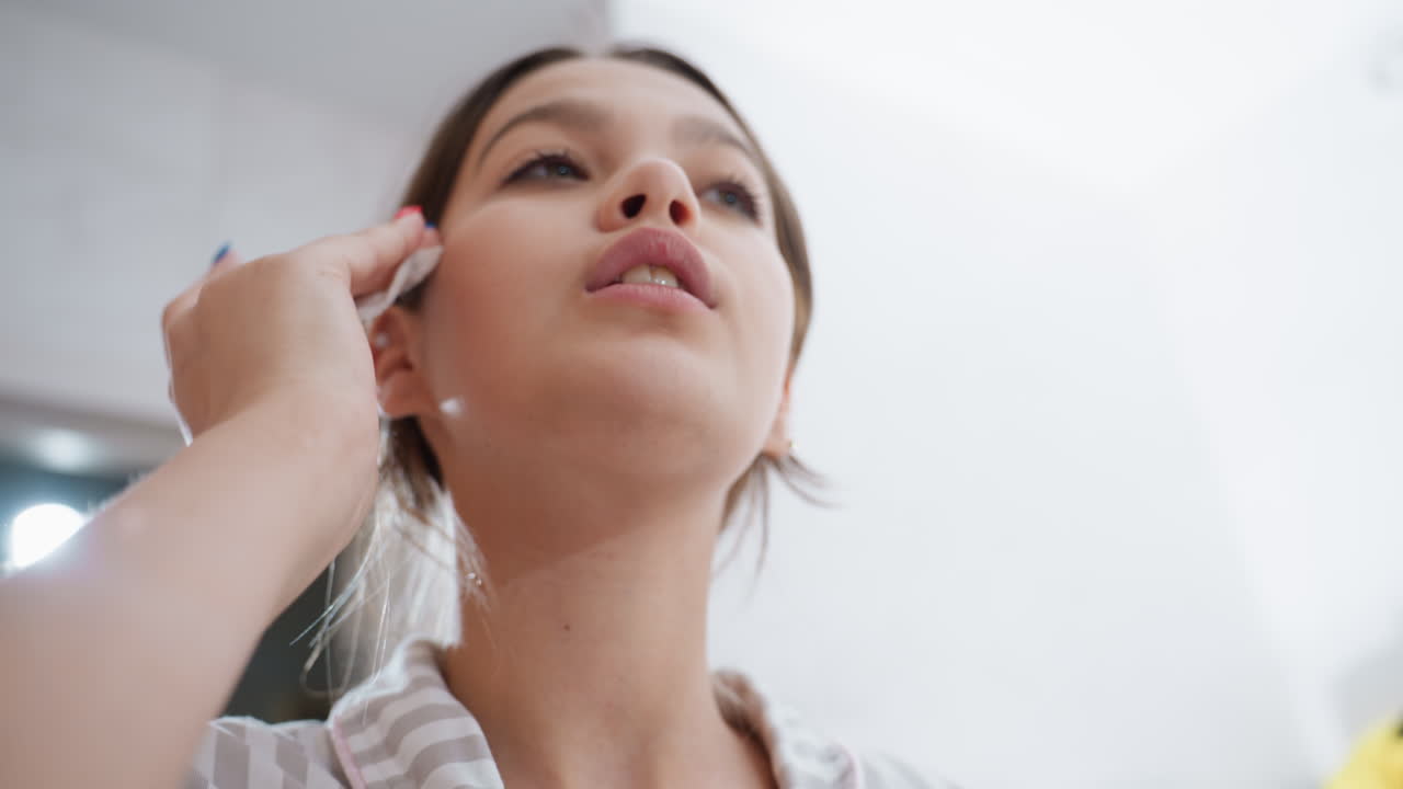 Woman Removing Eye Makeup With Cotton, Pad, Closeup Of Eyelid And Lashes, Gentle Circular Motions With Micellar Solution, Mirror Reflection, Bathroom Amber Light, Nightly Skincare Ritual