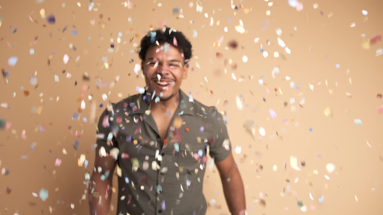 Cheerful man celebrating big win showered in confetti