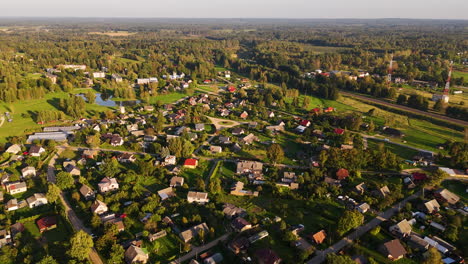 Drone footage capturing Augšlīgatne, Latvia, a picturesque rural village surrounded by lush greenery and rolling landscapes.