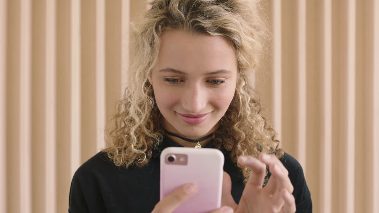 ritratto al rallentatore di una carina giovane donna bionda che sorride godendosi di messaggi di testo navigando utilizzando la tecnologia dei social media dello smartphone