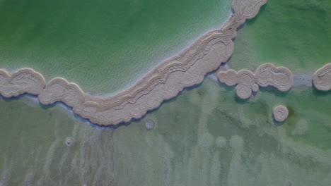 vista de arriba hacia abajo de enormes trozos de sal creados por el movimiento del agua en el mar muerto