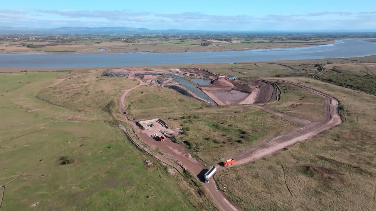 River Wyre And Open Landfill Site With Moving Trucks. Jameson Road Landfill And Recycling Site, Fleetwood, UK