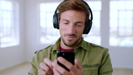 man using mobile phone while wearing headphones