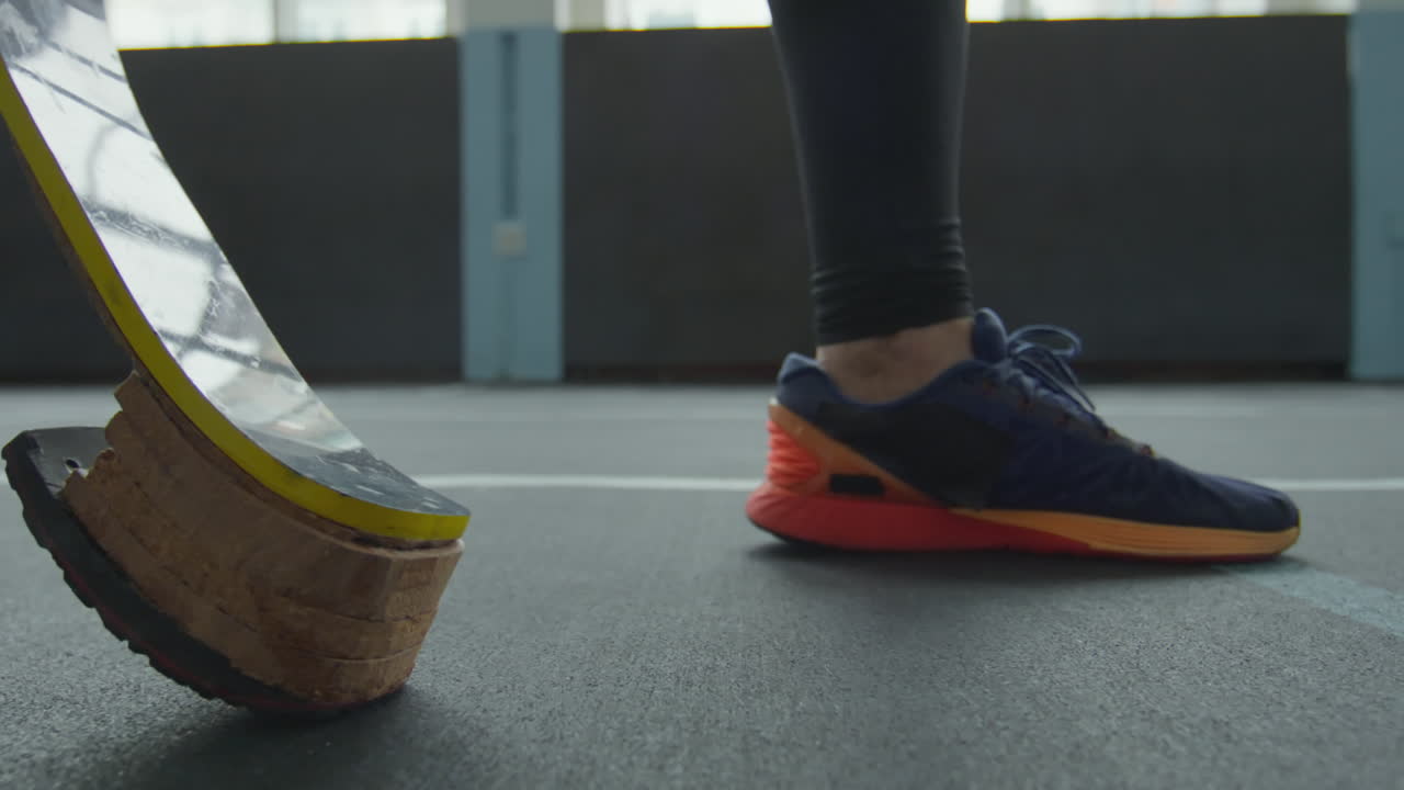 Athlete with Prosthetic Running Blade Walking on Stadium Track