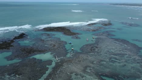 coral reef with boats on natural pool at coral coast of maragogi in alagoas, brazil