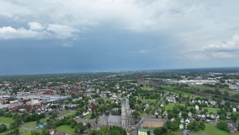 an aerial view of the green city of buffalo, new york with storm clouds in the distance