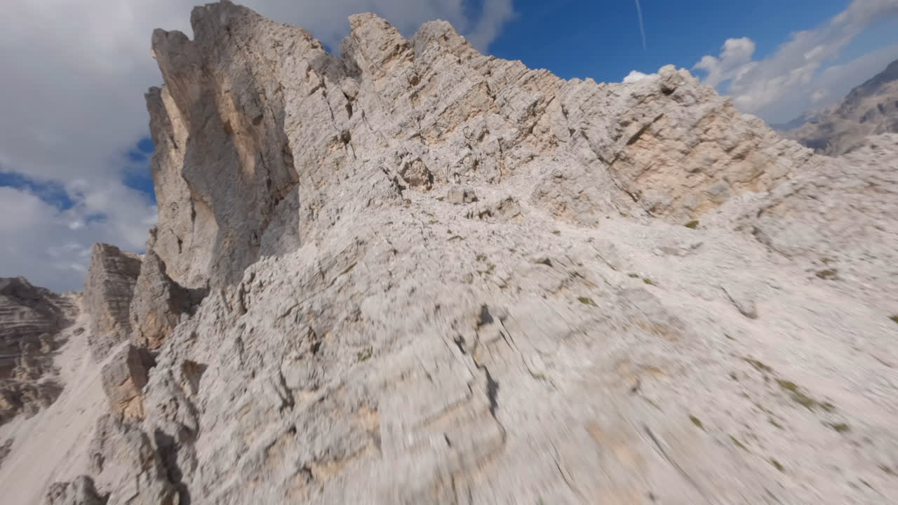 dron fpv ascendiendo dolomitas rocosas afiladas cimas de la cordillera italiana