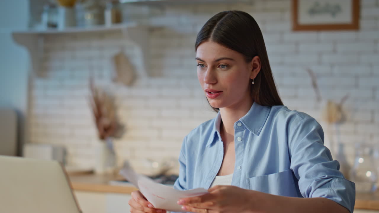 Cheerful lady video chatting looking laptop camera in apartment kitchen closeup