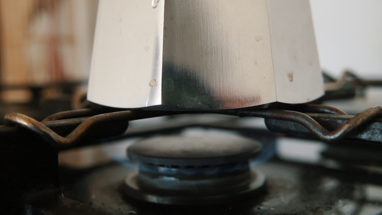 오래된 이탈리아 전통 모카 냄비에 커피를 끓이는 가스레인지의 불꽃을 닫습니다